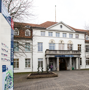 ein wei&szlig;es Geb&auml;ude mit einem Schild davor