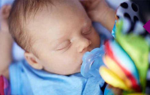 ein Baby, das mit einem Schnuller schl&auml;ft