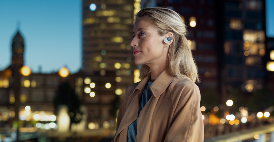 Une femme portant des &eacute;couteurs intra-auriculaires antibruit Philips en ville