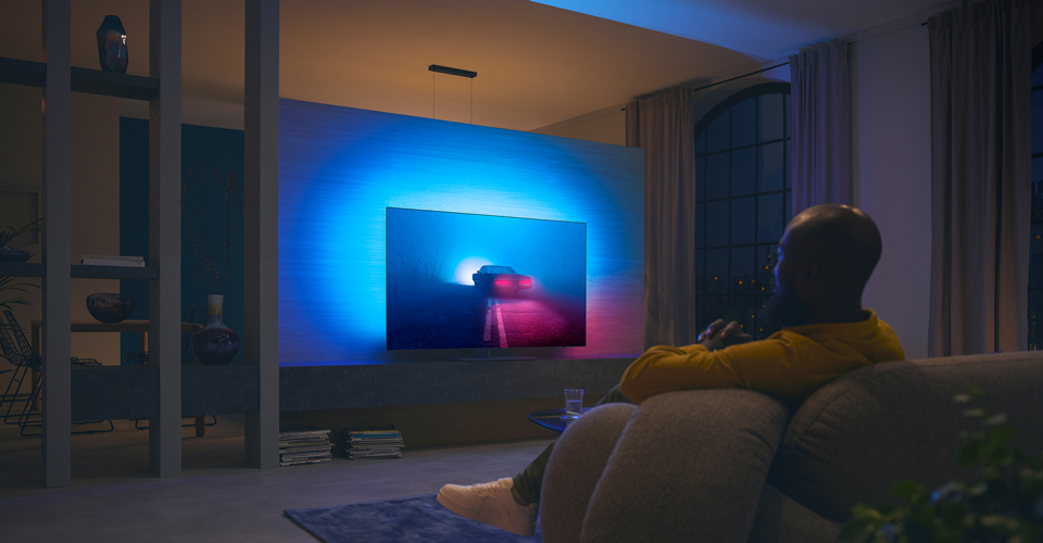 Un couple regarde un film sur un t&eacute;l&eacute;viseur Ambilight