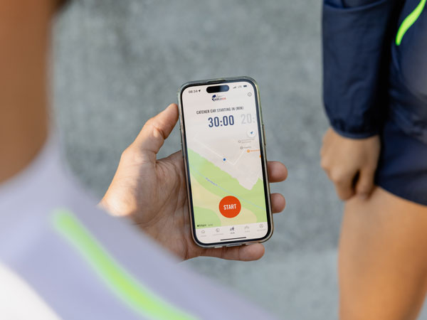 Ein Teilnehmer am Lauf checkt sein Telefon und wartet auf den Startschuss für den Lauf.