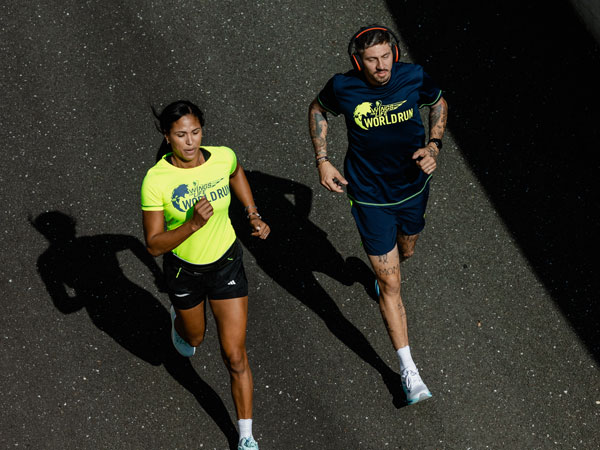 Zwei Läufer geben alles, um schneller als das Catcher Car zu sein.